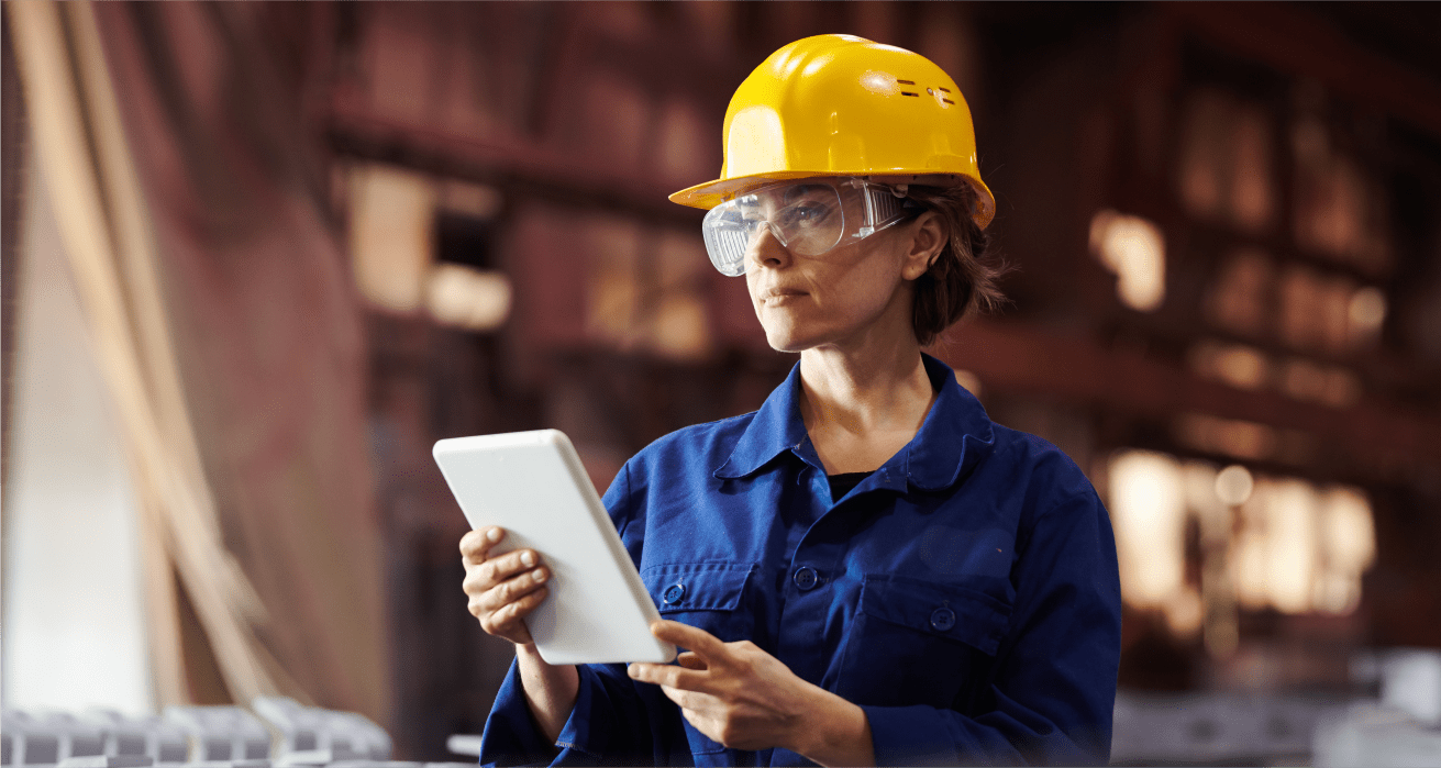 Warehouse worker in a hard hat reviewing a document