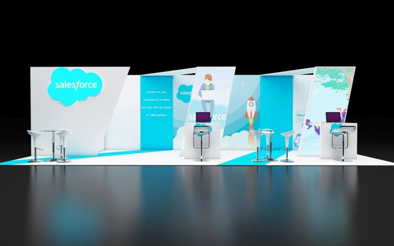 Salesforce booth with turquoise-and-white angled walls, product illustrations and high meeting tables.